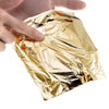 A hand is holding a sheet of imitation gold leaf for crafting or gilding.