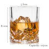 A heavy base tumbler whiskey glass filled with amber liquid and ice cubes.