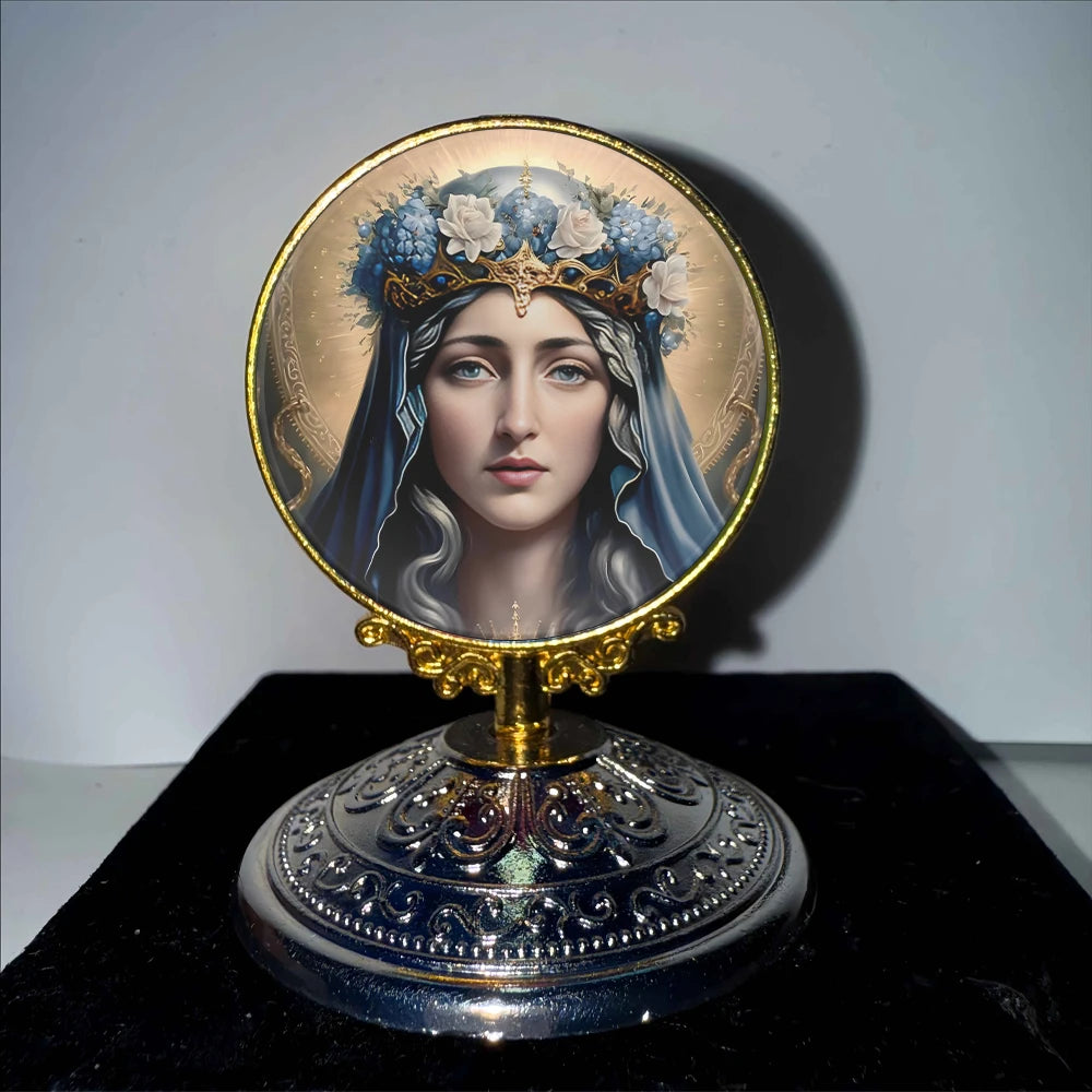 A golden framed religious medallion featuring a serene female face with blue hair and crown.
