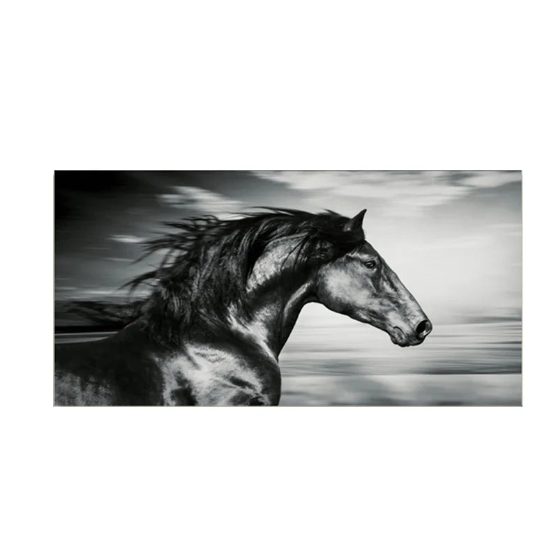 Black and white photograph of a horse galloping against a cloudy sky.