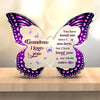 A purple and pink acrylic butterfly keepsake with engraved text that reads Grandma I love you.