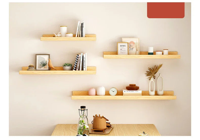 A display of natural wood floating shelves mounted on a light beige wall, featuring various decorative items and books.