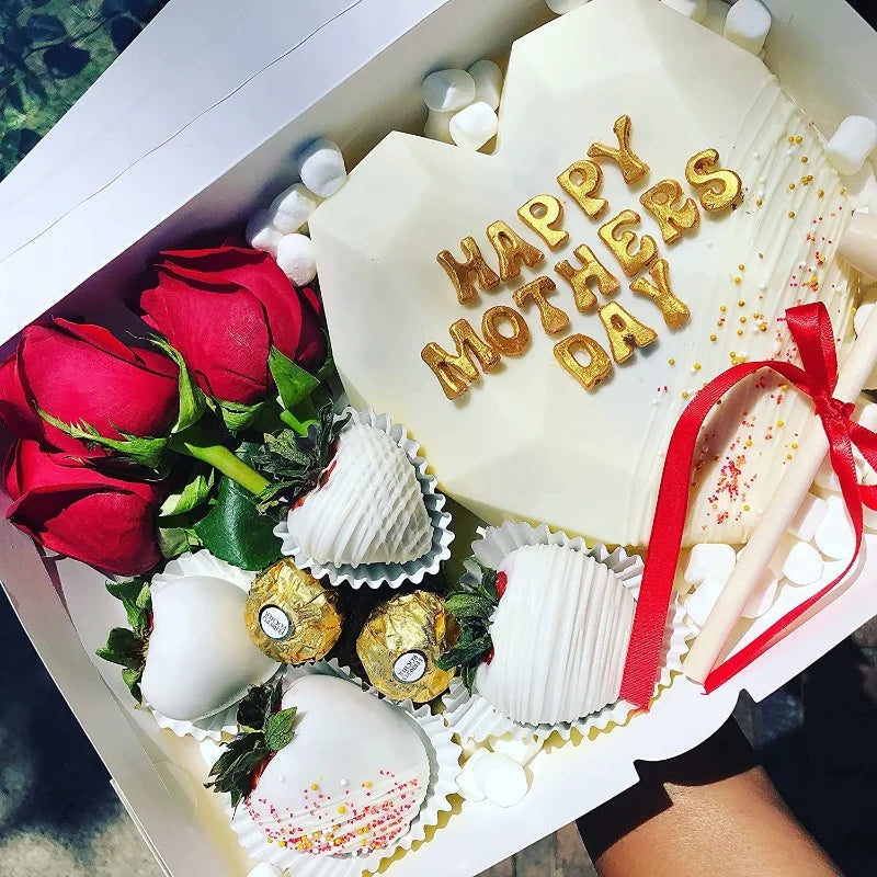 A white heart-shaped chocolate mold set decorated with gold letters and numbers for Mother's Day
