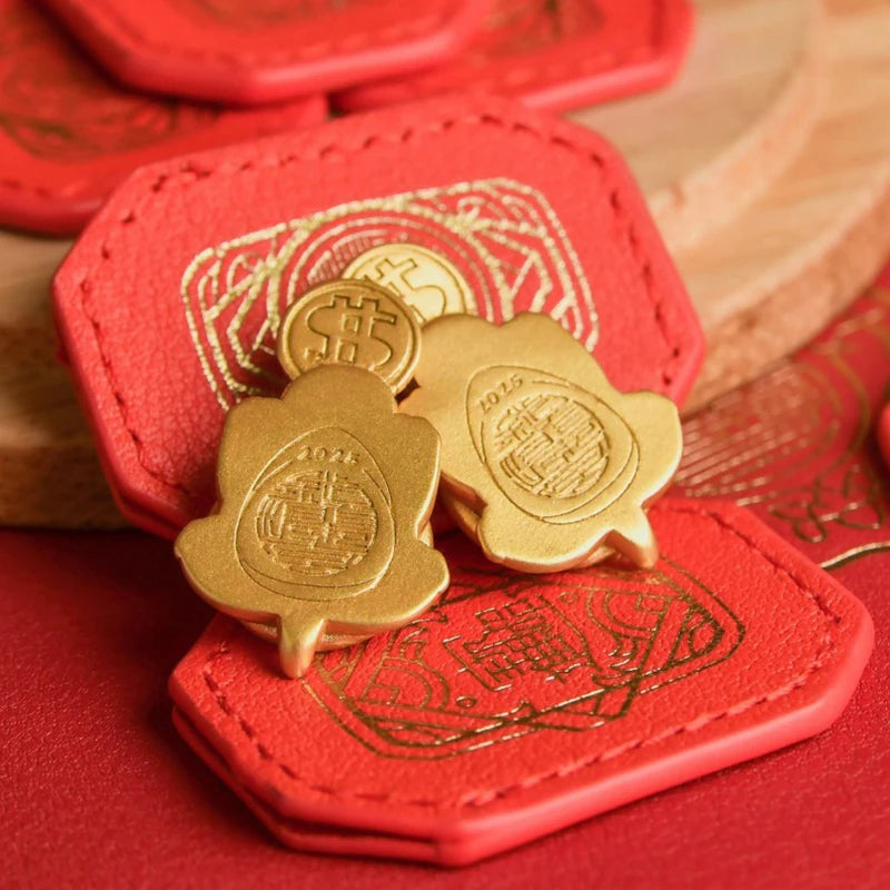 A set of gold tortoise figurines with intricate patterns resting on a red felt background.