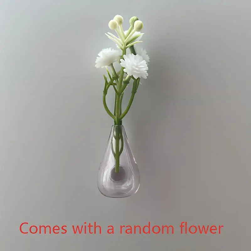 A single white flower arrangement in a clear glass vase on a light gray background.