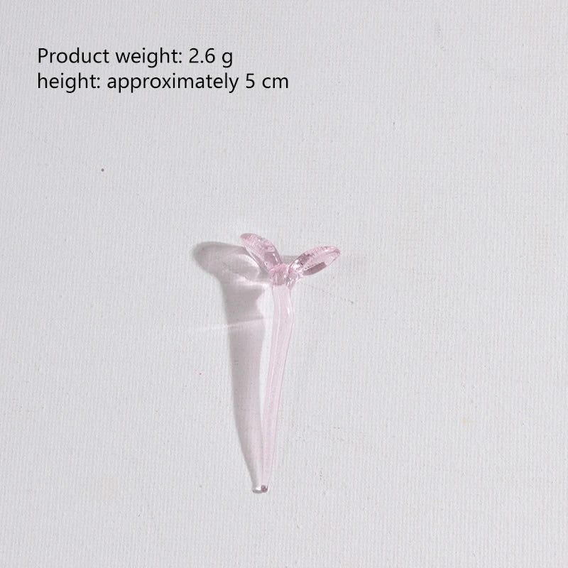 A small, translucent pink glass flower in a vase shape.
