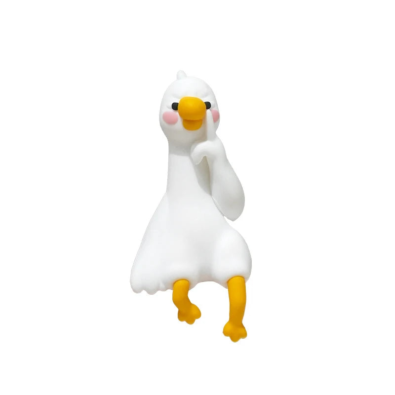 Figurine de canard en résine blanche avec des pattes jaunes et des accents roses.