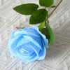 A light blue artificial rose with green leaves resting on a white textured surface.