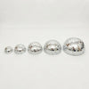 A set of five silver disco balls with adhesive backing arranged in a row.