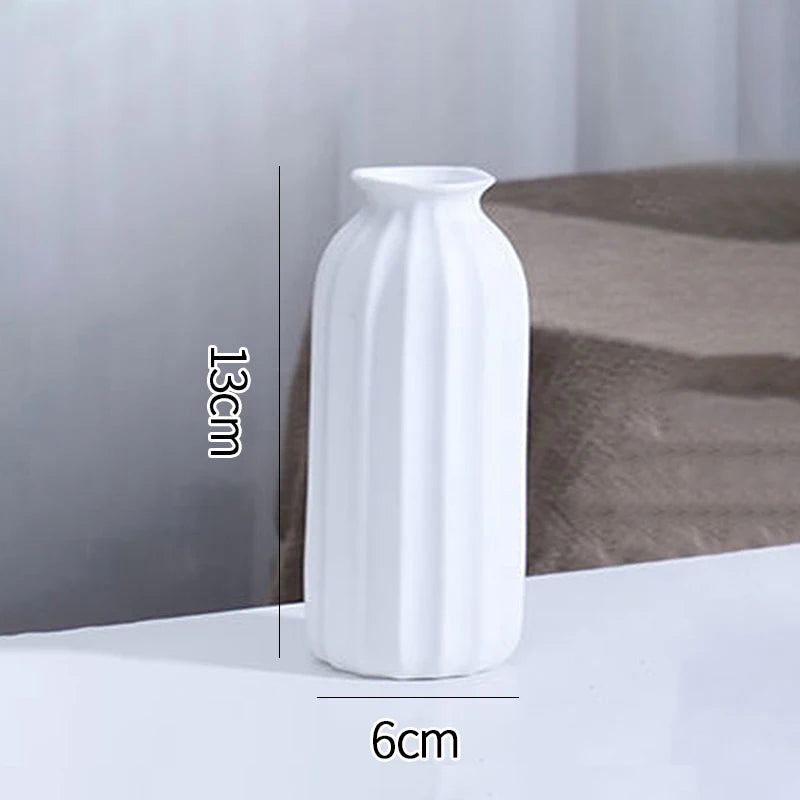 A white ceramic bud vase with vertical ridges is shown on a surface, with dimensions indicated.