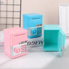 A set of pink and light blue mini piggy banks and money boxes displayed on a white surface.