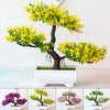 Un arbre bonsaï artificiel réaliste avec un feuillage jaune vif dans un pot blanc.