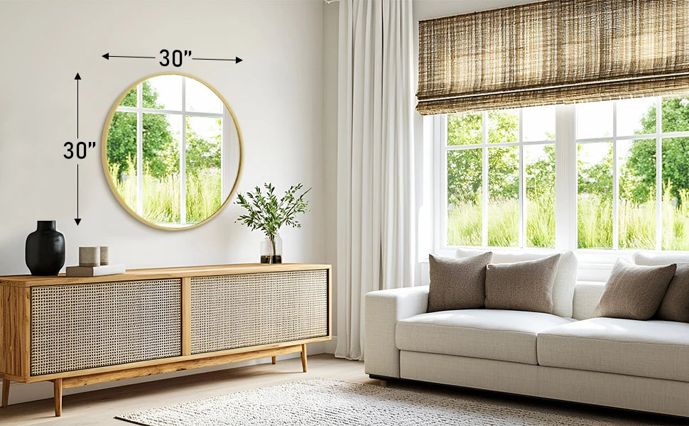 A modern living room features a large round vanity mirror with a matte metal frame above a wooden cabinet and a light-colored