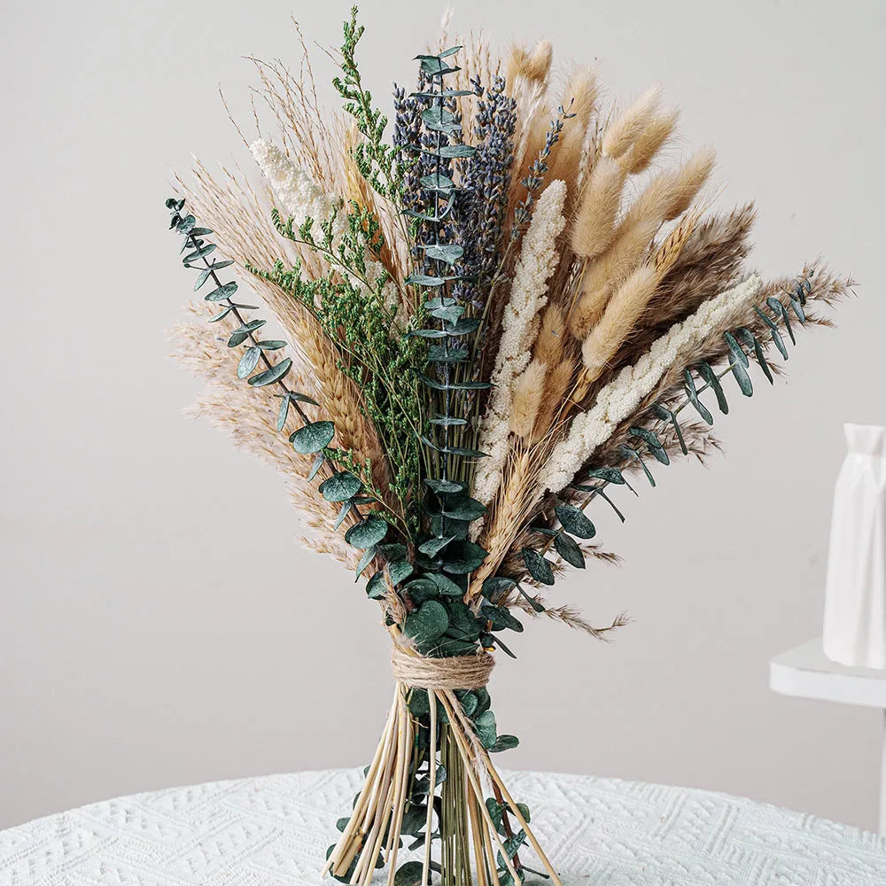A dried flower bouquet featuring various grasses and eucalyptus in muted natural tones.