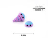 Pink and blue jellyfish figurine with iridescent stripes and large eyes.