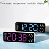 A digital wall clock displaying time, temperature, and humidity on a light blue surface.