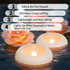 A set of floating LED candles with a warm white glow are shown resting on water.