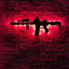 A black gun-shaped LED light fixture mounted on a red brick wall.