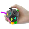 A hand holds a black fidget cube with colorful accents and a purple stick, demonstrating a sensory desk toy.