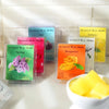 A collection of scented wax melts in various colors including pink, green, and yellow, packaged for DIY candle making.