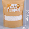 A brown paper bag containing 1000g of white beeswax pellets for candle making