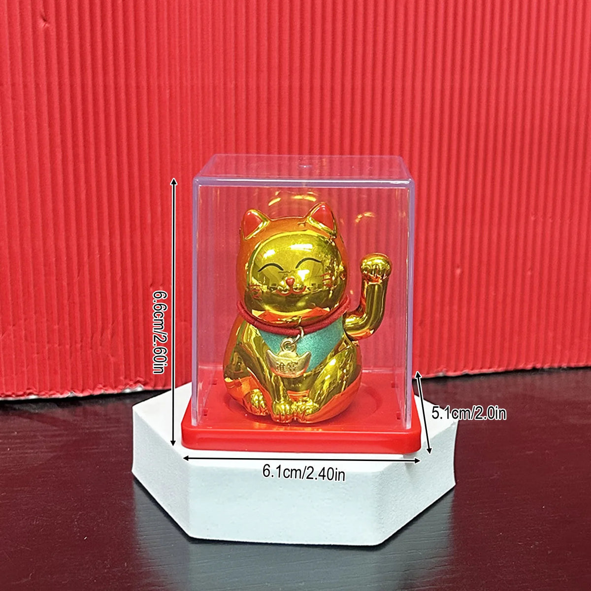 A golden solar-powered waving lucky cat figurine displayed in a clear acrylic box.