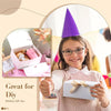 A smiling girl holds a white gift box with a ribbon tie, set against a background featuring pink and purple accents.