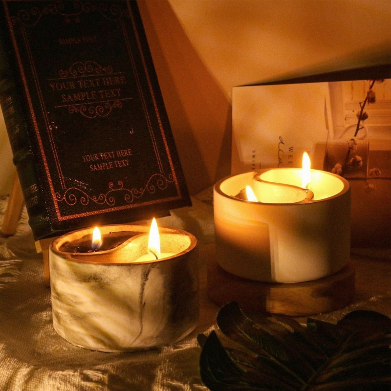 A set of glowing candles in natural-toned holders resting on a draped fabric.
