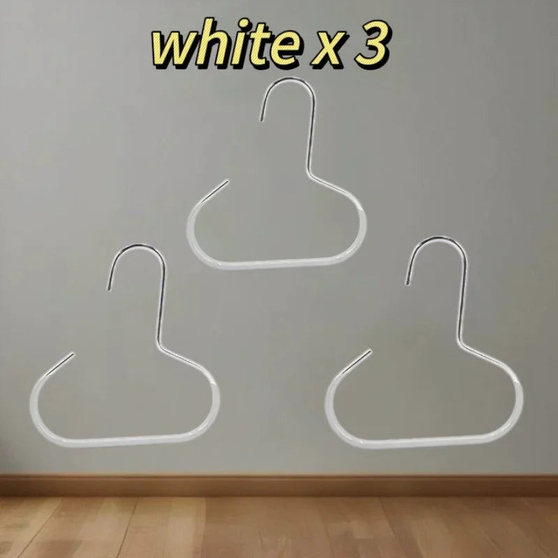 Three white hat organizer racks hanging on a wall.