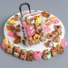 A collection of small capybara figures in various colors and textures arranged on a white round tray.