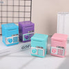 A set of colorful kids mini piggy banks and money boxes in blue, purple, and pink sitting on a white surface.