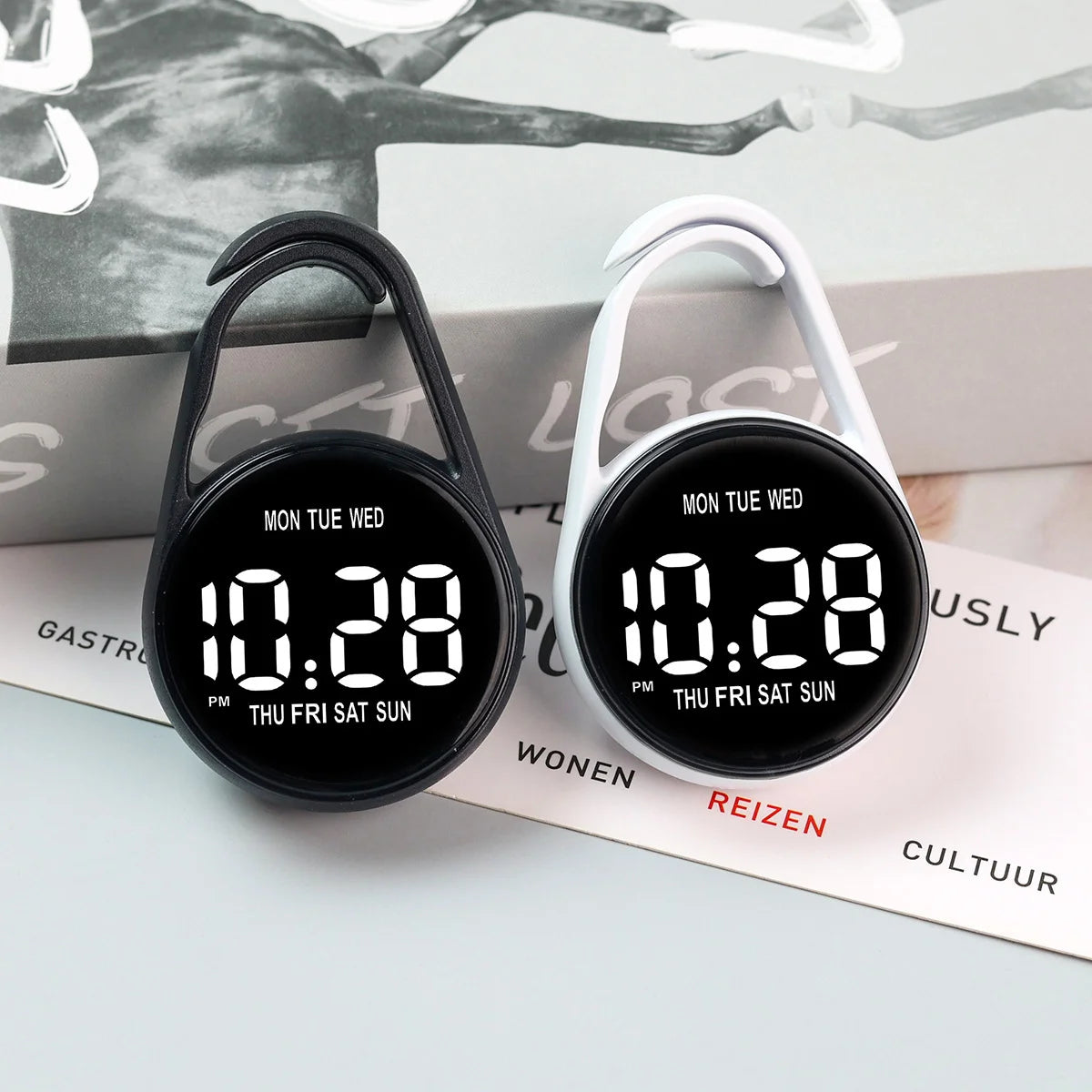 A black and white LED pocket watch with a white casing displaying the time 10:28 on a light gray background.