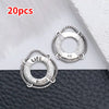 20 pieces of silver vintage ship anchor charms for jewelry making displayed on a dark surface.