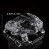 Clear glass miniature tortoise statue with a reflective surface shown from above.