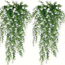 A set of three lifelike faux eucalyptus hanging plants with green leaves and white flowers.