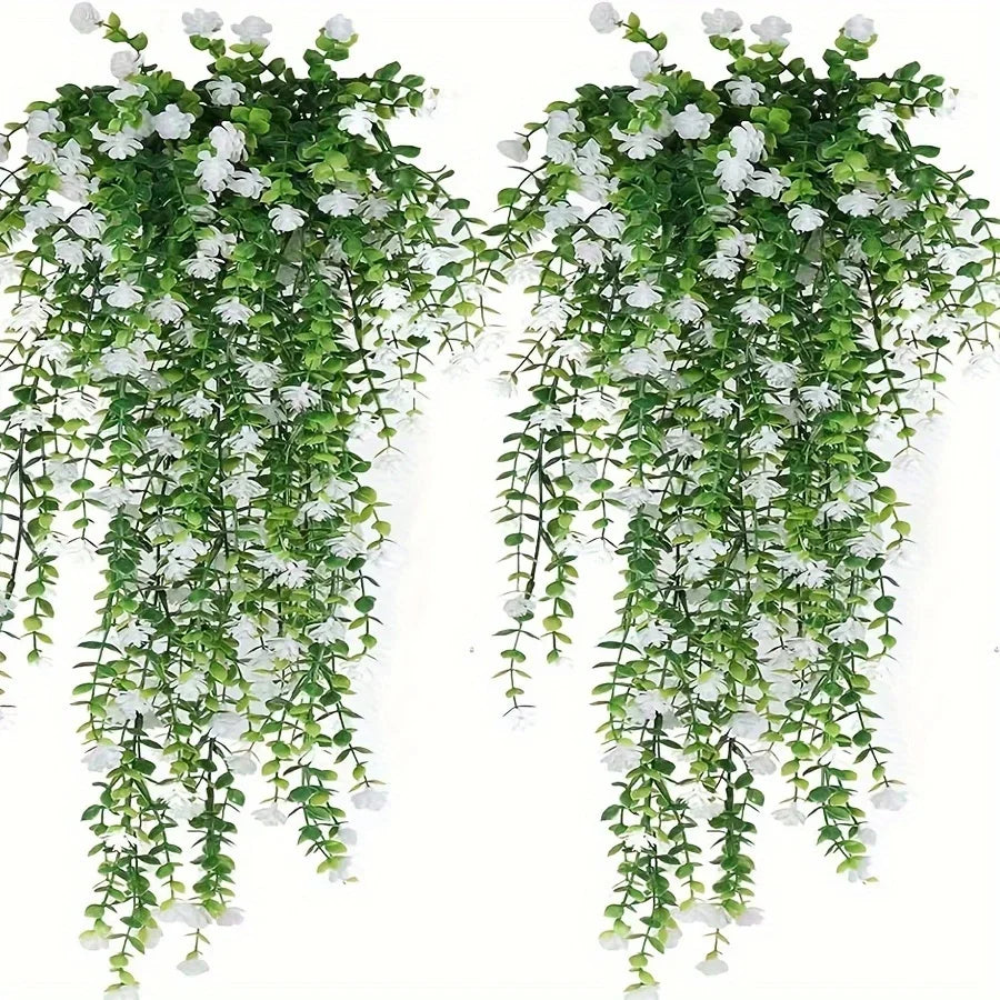 A set of three lifelike faux eucalyptus hanging plants with green leaves and white flowers.
