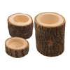 A set of rustic wooden tree stumps used as candle holders.