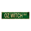 Vintage green metal sign with distressed lettering that reads OZ WITCH WAY