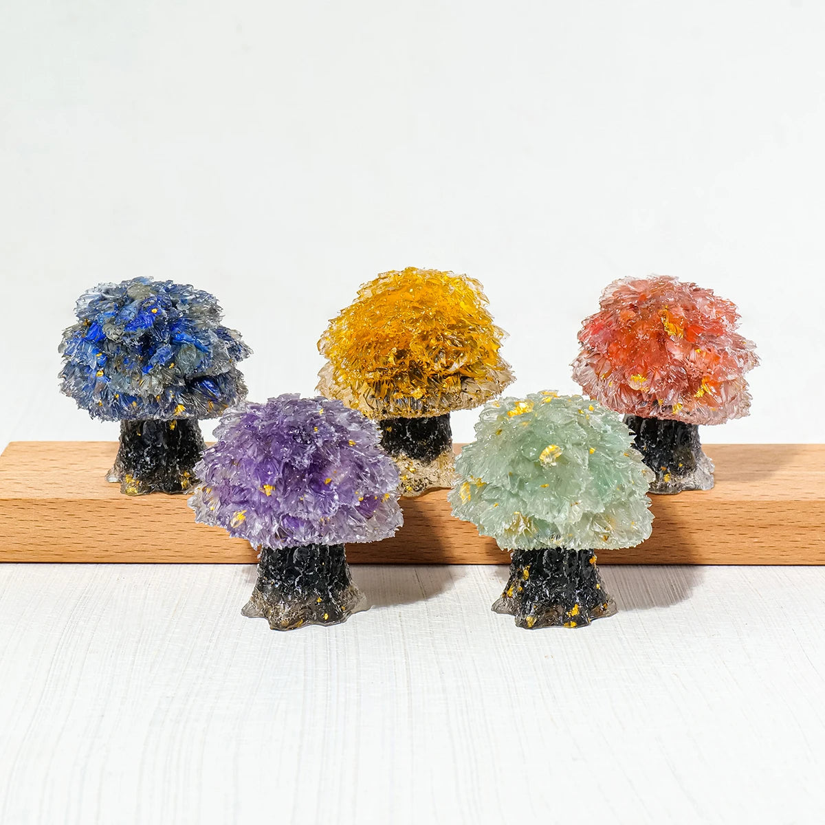 A collection of natural crystal mushroom trees displaying various colors including blue, yellow, and reddish-orange.
