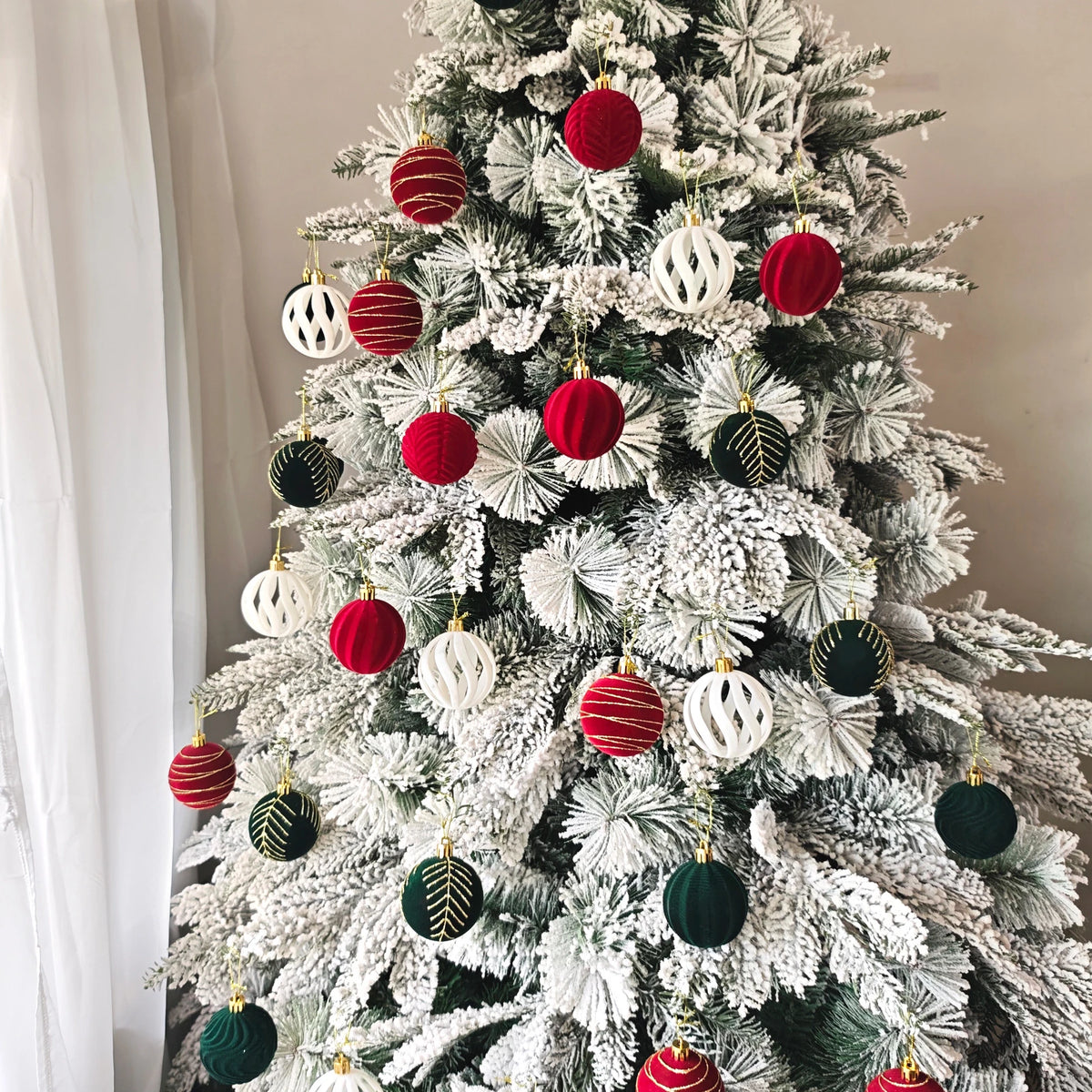 A decorated Christmas tree featuring a variety of red, white, and green velvet baubles and ornaments.