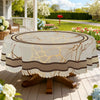 A round tablecloth featuring a marble stripe pattern in beige and brown tones with gold accents, set outdoors.