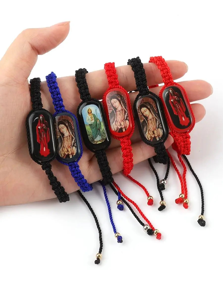A hand holds several vintage wooden Virgin Mary prayer bracelets in various colors like black, blue, green, and red.