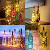 Ten glass wine bottles filled with LED lights arranged on a surface.