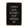 A dark, distressed metal sign with white text that reads I'm not a social butterfly I'm an antisocial bat.