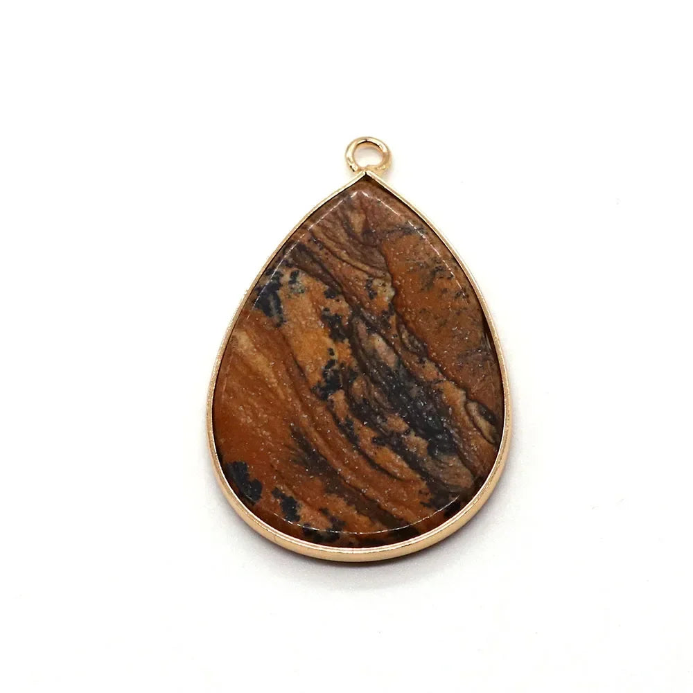 A teardrop-shaped natural agate pendant with a gold-colored bail, featuring brown and black swirling patterns.
