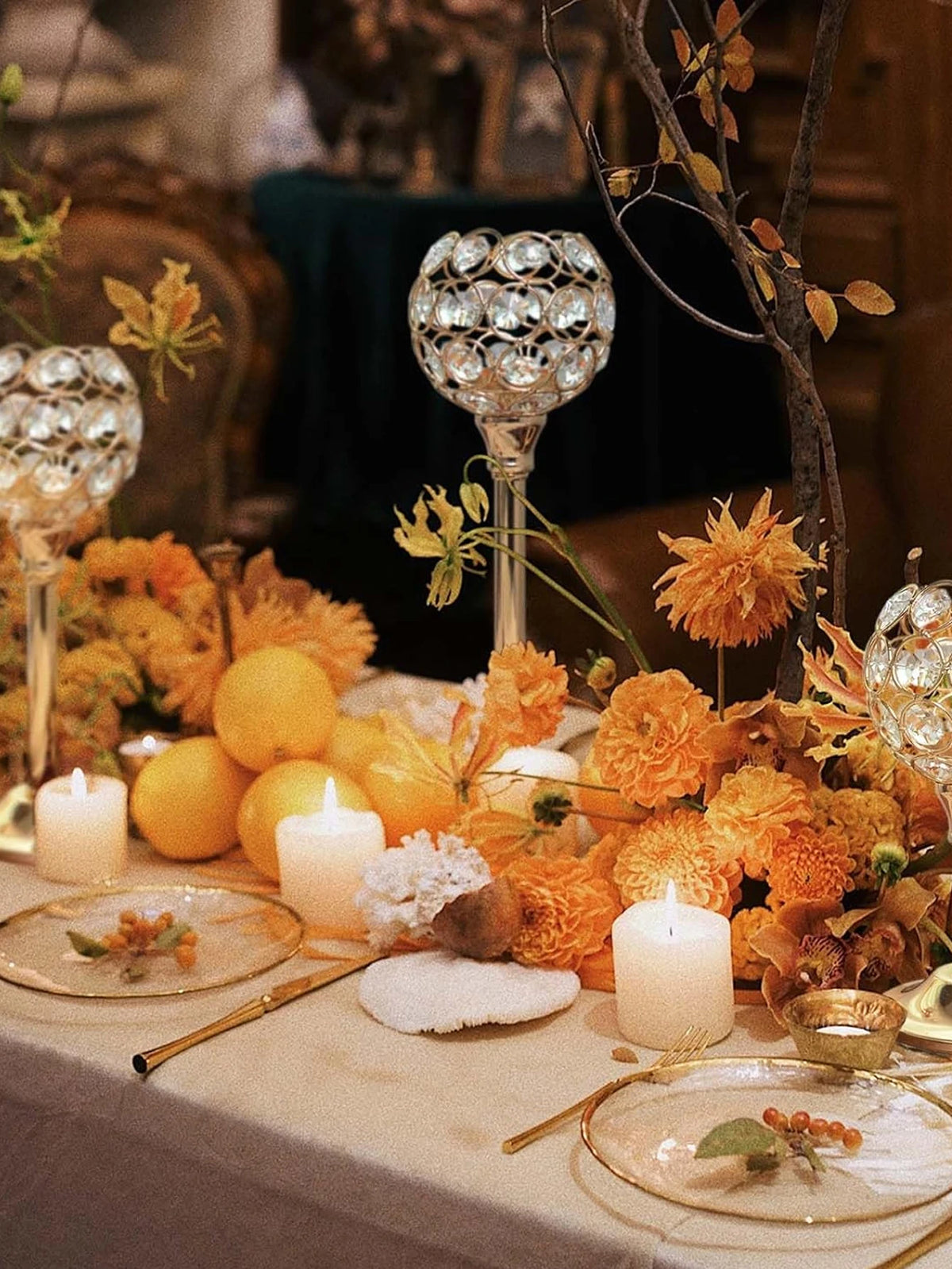 A close-up of a crystal candle holder with a golden finish used as a decorative tealight stand in an autumnal centerpiece arr