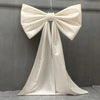 A large white satin bow with long tulle drape used for event decoration.