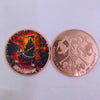 A copper challenge coin featuring a grim reaper design with skulls and a pirate theme.