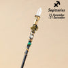 A natural clear quartz zodiac crystal wand with gold accents and a green bead, used for meditation and healing.