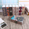 A collection of stacked dark-colored dictionary-style lock boxes featuring various country names and flags.